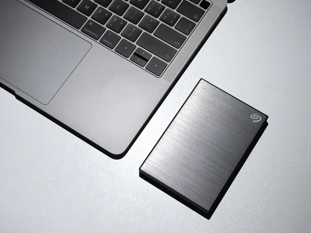 Bild von einer externen Festplatte neben einem MacBook.